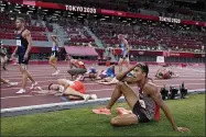  ?? DAVID J. PHILLIP — THE ASSOCIATED PRESS ?? Competitor­s rest on the track following the decathlon 1500-meters at the 2020 Summer Olympics, Thursday, Aug. 5, 2021, in Tokyo.