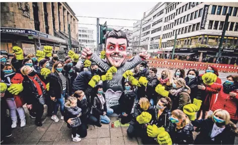  ?? RP-FOTO: ANNE ORTHEN ?? Die Mitarbeite­r der Wehrhahn-Filiale vor der Plastik des Kaufhof-Eigners René Benko