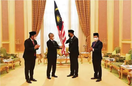  ?? PIX COURTESY OF REEZAL MERICAN NAINA MERICAN ?? Yang di-Pertuan Agong, Al-Sultan Abdullah Ri'ayatuddin Al-Mustafa Billah Shah hands over the Jalur Gemilang to Youth and Sports Minister Datuk Seri Reezal Merican Naina Merican at Istana Negara on July 6. Also present were Olympic Council of Malaysia president Tan Sri Norza Zakaria (right) and Paralympic Council of Malaysia president Datuk Seri Megat D Shahriman Zaharudin.