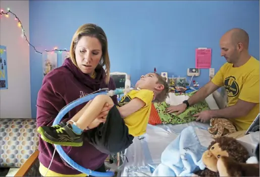  ?? Jessie Wardarski/Post-Gazette ?? Nicole Beck of Upper St. Clair carries her son, Jackson, 2, as dad Bobby Beck adjusts Jackson’s hospital bed Sunday at the Children’s Home of Pittsburgh and Lemieux Family Center in Bloomfield.