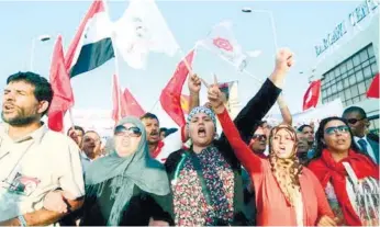  ?? (AFP FOTO) ?? TUNISIANS MARCH outside the National Assembly in Tunis. Thousands of Tunisians took to the streets of Bardo, near the capital Tunis, calling for the government led by the moderate Islamist Ennahda party to step down.