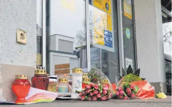  ?? FOTO: FLORIAN PEKING ?? Vor dem Geschäft Megamix in Markdorf haben am Montag zahlreiche Menschen als Zeichen der Anteilnahm­e Blumen abgelegt und Kerzen entzündet.