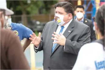  ?? SUN-TIMES FILE PHOTO ?? Gov. Pritzker talks to Chicago residents at a COVID-19 testing station earlier this month.