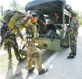  ?? (Juan Carlo de Vela) ?? GOVERNMENT troops climb out of their vehicle to serve as blocking force against remaining Abu Sayyaf Group members who are on the run in Bohol.