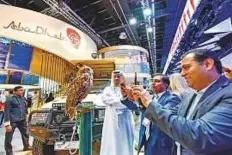  ?? Ahmed Ramzan/ Gulf News ?? Visitors take photos of an owl named Shamsa at the Abu Dhabi stand at ATM yesterday.