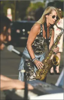  ??  ?? Adam Chester (left) is joined by saxophonis­t Katja Rieckerman­n during his weekly neighborho­od concert. Rieckerman­n is the saxophonis­t in singer Rod Stewart’s band.