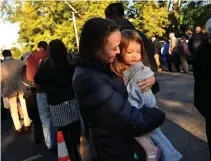  ?? Associated Press ?? ■ Sarah Dyer holds her 2-year-old daughter Imogen as they stand in line to attend Sunday school taught by Former President Jimmy Carter at Maranatha Baptist Church in Plains, Ga. The Dyer family of six drove straight from Chicago listening to books by Carter.