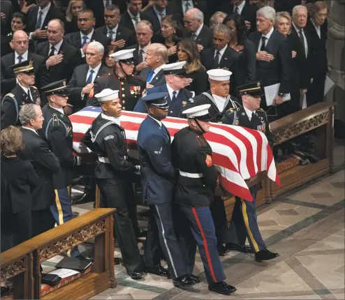  ?? Carolyn Kaster / Associated Press ?? The flag-draped casket of former President George H.W. Bush is carried by a military honor guard past former President George W. Bush and wife Laura Bush, President Donald Trump, first lady Melania Trump, former President Barack Obama, Michelle Obama, former President Bill Clinton, former Secretary of State Hillary Clinton, former President Jimmy Carter and Rosalynn Carter during a state funeral at the National Cathedral on Wednesday in Washington.