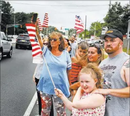  ?? Seth Wenig ?? The Associated Press People watch Monday as a motorcade escorting the remains of Marine Cpl. Dan Baldassare passes through Howell, N.J.