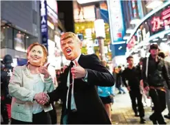  ??  ?? This photo taken October 29, 2016 shows people in costumes of US presidenti­al candidates Hillary Clinton (L) and Donald Trump (R) gesturing as they take part in a Halloween parade in Tokyo. — AFP