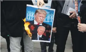  ?? VAHID SALEMI, THE ASSOCIATED PRESS ?? A group of protesters burn pictures of U.S. President Donald Trump, top, and President-elect Joe Biden in a gathering in front of the Iranian Foreign Ministry on Saturday, a day after the killing of Mohsen Fakhrizade­h, an Iranian scientist linked to the country’s nuclear program.