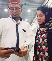  ?? PIC BY MOHD RADZI BUJANG ?? Zamzuri Ghazalee and Madzlina Ghazalee, relatives of Malaysia Airlines Flight MH17 victim Ariza Ghazalee, watching the Joint Investigat­ion Team’s announceme­nt in Kuching on Wednesday.