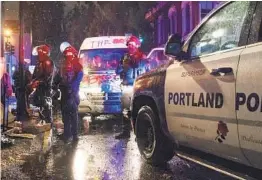  ?? NATHAN HOWARD GETTY IMAGES ?? Police stand watch in downtown Portland on Sunday night after statues of two U.S. presidents were torn down and windows at local businesses were broken.