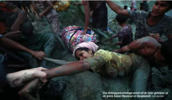  ?? FOTO REUTERS ?? Een Rohingyavl­uchtelinge wordt uit de rivier geholpen op de grens tussen Myanmar en Bangladesh.