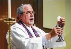  ??  ?? Giblin, a one-time chemical plant laborer, prepares communion during a service at St. Paul’s Episcopal Church in Orange.