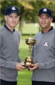  ?? CHRIS CARLSON — THE ASSOCIATED PRESS FILE ?? In this file photo, USA’s Ryder Cup captain Davis Love III, left, and player Jim Furyk pose with the Ryder Cup trophy during the Ryder Cup golf tournament, at the Medinah Country Club in Medinah, Ill. The Americans have a system where the same players...