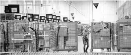  ?? TODD MCINTURF/AP FILE ?? Associates move bins at the loading dock of an Amazon fulfillmen­t center in Michigan.