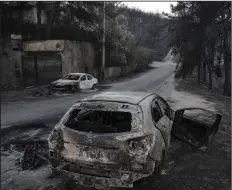  ?? Bloomberg photo by Yorgos Karahalis. ?? At let, burnt automobile shells line the streets following a wildfire at Neos Voutzas village, east of Athens, Greece, on July 25, 2018. Scientists can point to two things for the increase in global fires — a kink in the jet stream and the overall...