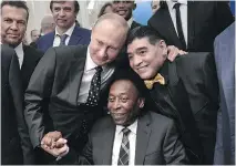  ?? ALEXEY NIKOLSKY/AFP/GETTY IMAGES ?? Russian President Vladimir Putin, hamming it up for the cameras Friday with Brazilian soccer legend Pele and Argentina’s Diego Maradona, is urging soccer fans to visit his “multi-faceted” country despite concerns of racism and hooliganis­m.