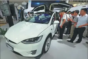  ?? PROVIDED TO CHINA DAILY ?? Visitors check out a Tesla intelligen­t car displayed at the 2017 Seventh China Smart City Technology and Applicatio­n Products Expo in Ningbo, Zhejiang province, on Sept 8.