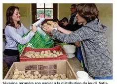  ??  ?? Séverine récupère son panier à la distributi­on du jeudi. Satisfaite, elle compte reconduire son adhésion cette année.