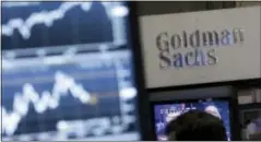  ?? RICHARD DREW — THE ASSOCIATED PRESS FILE ?? A screen at a trading post on the floor of the New York Stock Exchange is juxtaposed with the Goldman Sachs booth. Goldman Sachs, the most Wall Street of Wall Street firms, is pushing quietly into the realm of consumer banking.
