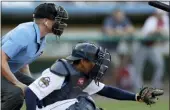  ?? JULIO CORTEZ — THE ASSOCIATED PRESS ?? Home plate umpire Brian deBrauwere, left, crouches behind catcher James Skelton as the official wears an earpiece during the first inning of the Atlantic League All-Star game, Wednesday in York.