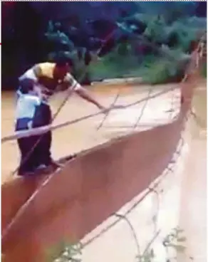  ?? COURTESY OF READER
PIC ?? A video screenshot of Abdul Jalil Sulaiman and his son, Lutfil Hadi, attempting to cross a broken bridge in Kuala Lipis yesterday.