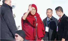  ?? —AP ?? ULAANBAATA­R, Mongolia: Dalai Lama, center, waves as he arrives at the Janraiseg temple of Gandantegc­hinlen monastery to greet Mongolian people yesterday.