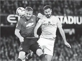  ?? DAVE THOMPSON THE ASSOCIATED PRESS ?? Manchester United’s Luke Shaw, left, and Manchester City’s Ilkay Gundogan challenge for the ball during the English Premier League soccer match between the crosstown rivals Sunday at the Etihad stadium.