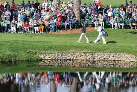  ?? PHOTOS BY CURTIS COMPTON / CCOMPTON@AJC.COM ?? Jordan Spieth walks the fairway to the hole on 15 during the final round of the Masters on Sunday. The 2015 Masters winner and two-time runner-up finished third despite a final round of 64 that tied his career best at Augusta.