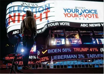  ?? TODD HEISLER/THE NEW YORK TIMES ?? A man stops in Times Square in New York to check the election results early Wednesday. Dawn broke over the U.S. with the presidenti­al election undecided and the specter of days of uncertaint­y ahead.