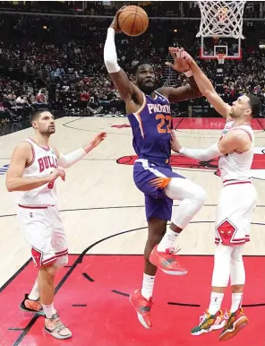  ?? AP PHOTOS ?? ABOVE: The Suns’ Deandre Ayton takes advantage of the Bulls’ porous interior defense. BELOW: Bulls guards Alex Caruso (left) and Lonzo Ball have missed time to injury.