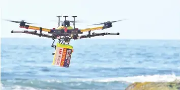  ?? — AFP photo ?? A file photo of a drone skimming across the ocean with a safety flotation device attached.