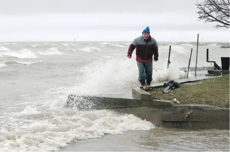  ?? NICK BRANCACCIO ?? Cedar Island resident Jim Norris has seen an angry Lake Erie many times since he moved there in 1971. Here Norris checks out breakwalls on Sunday as large waves crash ashore. OPP went door to door on Cedar Island to ensure people were safe.