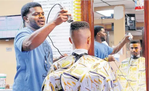  ?? [PHOTO BY JIM BECKEL, THE OKLAHOMAN] ?? Duce Talley gives a haircut to Xavier, who has been visiting Talley’s barber shop since the age of three, at Twice the Cutz Salon, near NE 10 and Douglas Blvd. in Midwest City.