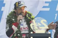  ??  ?? 2 Fernando Alonso on the podium at Le Mans after his Toyota team won for the first time.