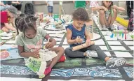  ??  ?? India Brown, 4, far left, and her cousin Melinia Murray, 3, work away at the “build a city” play section Saturday. The pop-up offered more space for pedestrian­s and bikes.