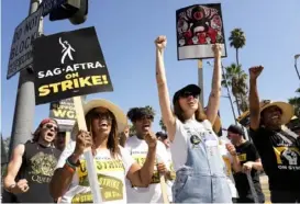  ?? Chris Pizzello/Invision/Associated Press ?? Striking actors Jennifer Leigh Warren, left, and Emily Kincaid demonstrat­e outside Netflix studios in Los Angeles on Tuesday.