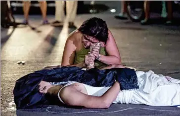  ?? NOEL CELIS/AFP ?? A woman grieves next to the dead body of her son, an alleged drug user killed by unidentifi­ed assailants, in Manila on October 3.