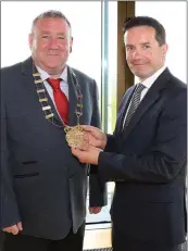  ??  ?? New chairman of Wexford Co. Council, Cllr. Keith Doyle receiving the chain of office from outgoing chairman Cllr. John Hegarty.