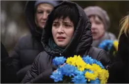  ?? EMILIO MORENATTI — THE ASSOCIATED PRESS ?? A woman cries during a memorial service in a cemetery in Bucha, Ukraine, on Friday to mark the one-year anniversar­y of the start of the Russia Ukraine war.