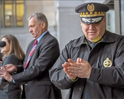  ?? Steph Chambers/Post-Gazette ?? Pittsburgh Police Chief Scott Schubert uses hand sanitizer Friday after a livestream­ed news conference regarding the COVID-19 outbreak outside the City-County Building in Downtown.