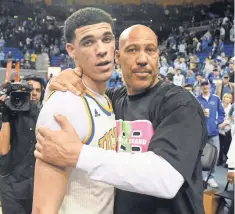  ?? RICHARD MACKSON, USA TODAY SPORTS ?? LaVar Ball embraces his son Lonzo after a UCLA game. Lonzo could be picked by the Lakers in next month’s draft.