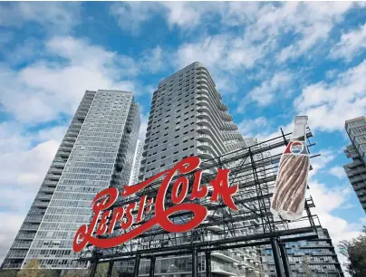  ?? AP PHOTOS ?? WILL COMPANY DELIVER? A landmark Pepsi sign, above, stands in Long Island City in the Queens borough of New York, also home to the MOMA PS1 art museum, left, and where Amazon plans to build its second headquarte­rs. Some residents doubt they will get any of the 25,000 jobs promised by the company. Below, antiAmazon graffiti on a Long Island City sidewalk.