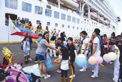  ??  ?? Well-wishers welcome the Superstar Virgo (below) at the Manila South Harbor.