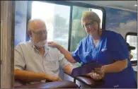  ?? NEWS PHOTO MO CRANKER ?? Clifford Garner goes over some informatio­n with nurse Joanne Skibsted Saturday afternoon in the Man Van. The van travels across Alberta testing men's blood in search for signs of prostate cancer.