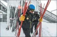  ?? PHILIPPE DESMAZES / AGENCE FRANCE-PRESSE ?? Members of the ski patrol carry poles to mark out a slope closed due to heavy snowfalls on Wednesday at a French ski resort.