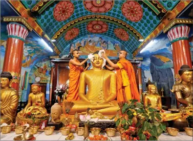  ??  ?? Buddhist monks clean a statue of Lord Buddha inside a temple ahead of the Buddha Purnima festival in Kolkata, on Tuesday. REUTERS