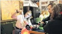  ?? PHOTO: REUTERS ?? Legal high . . . Chrissy Brun shows customers a cannabis menu at the Natural Vibe store after legal recreation­al marijuana went on sale in St John’s, Newfoundla­nd and Labrador yesterday.